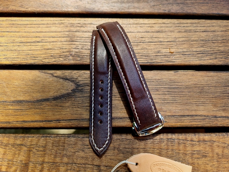 Mahogany Kangaroo leather strap for Grand Seiko Snowflake placed on wooden table